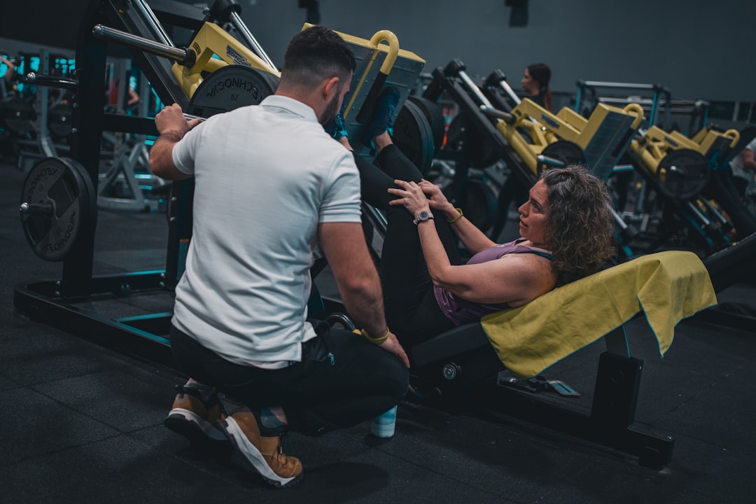 Personal trainer coaching an experienced gym client during a workout